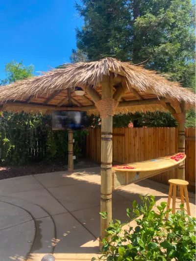 Palapa bar with stools on a backyard patio