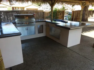 Outdoor kitchen with built-in grill under a palapa