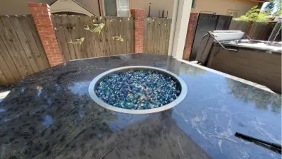 Fire table with blue glass on a covered patio