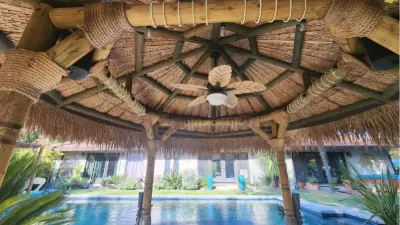 Looking out from under a palapa roof toward the pool
