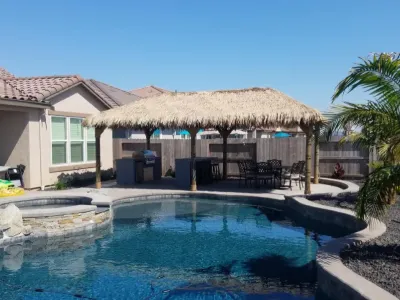 Palapa shading a dining patio beside a pool and raised spa