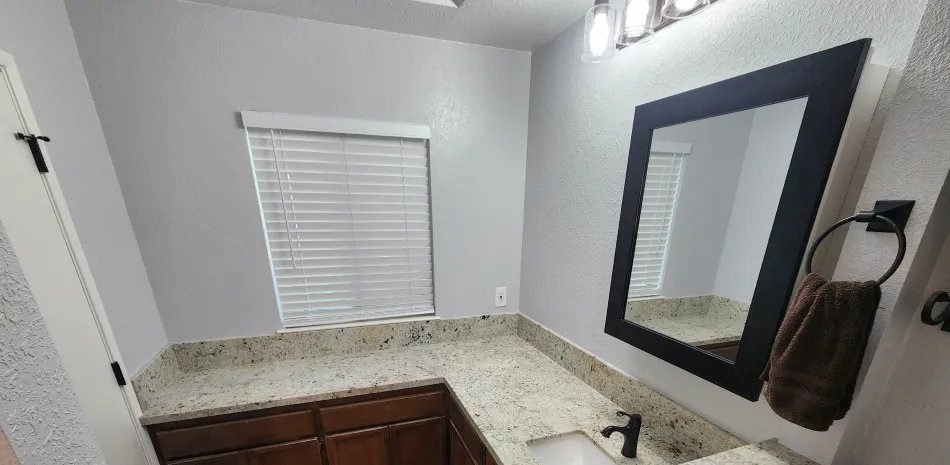 Freshly painted white bathroom walls with a granite vanity in Auburn, CA